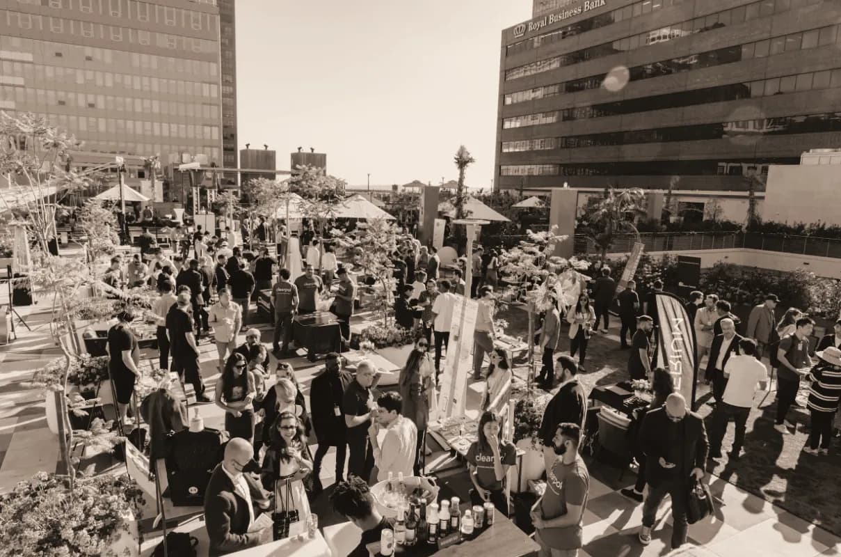 A large crowd of attendees at an outdoor startup event between office buildings