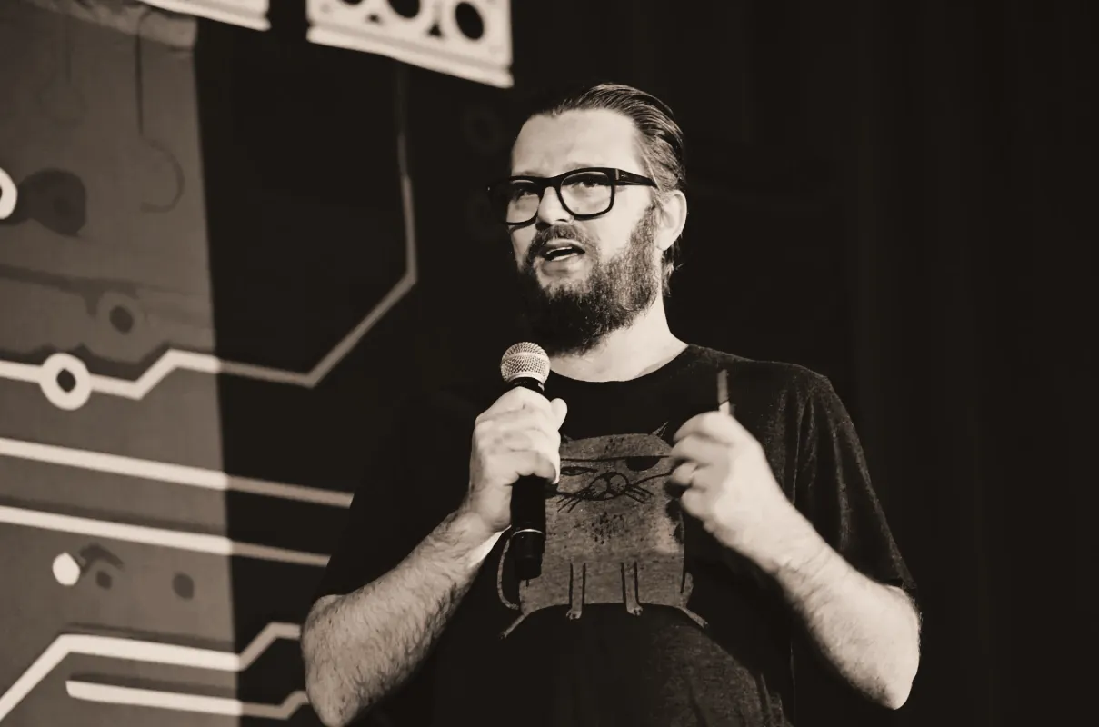 A speaker holding a microphone while presenting on stage